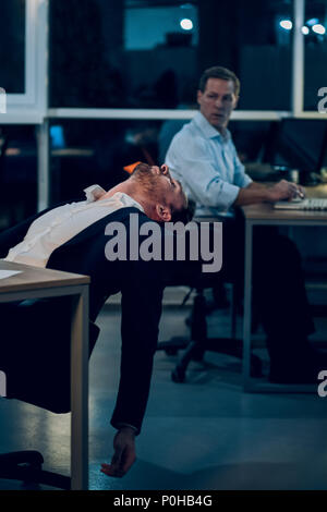 Businessman falling asleep during work. Stock Photo