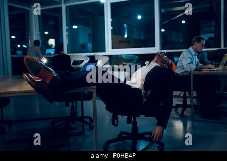 Businessman falling asleep during work. Stock Photo