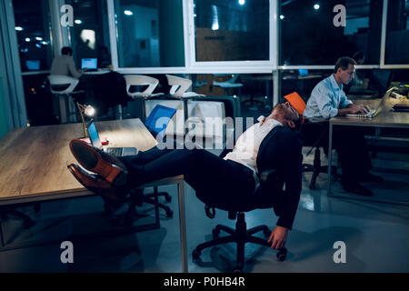 Businessman falling asleep during work. Stock Photo