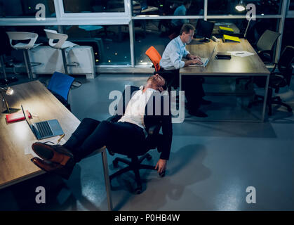 Businessman falling asleep during work. Stock Photo