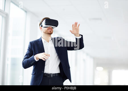 Young businessman using virtual reality technology at work Stock Photo
