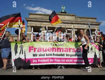 09 June 2018, Germany, Berlin: People taking part in the 'Frauenmarsch' (lit. women's march) by right-wing populist groups at the Brandenburg Gate. On the right in front of the banner is Leyla Bilge, the march organiser. Photo: Jörg Carstensen/dpa Stock Photo