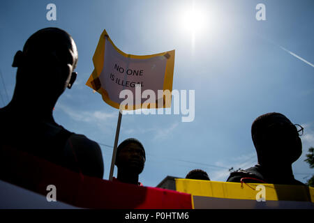 Milan, Italy - 9 June 2018: A man holds a placard  reading 'No one is illegal' during an anti-racist against the killing of Soumaila Sacko, a  29 years old Malian farm worker migrant, murdered in a shooting last Sunday in the village of San Ferdinando in the southern Italian region of Calabria. Stock Photo