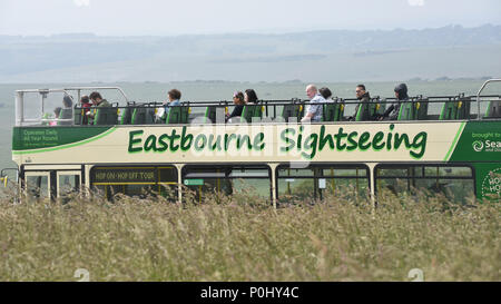 South Downs, UK.  9 June 2018.  Sightseers take a tour bus near Beachy Head on a warm afternoon.  In recent years, the area has been prone to erosion with areas of the chalk cliffs around Seven Sisters collapsing onto the beach below.  As a result walkers are warned not to go close to the cliff edge.  Credit: Stephen Chung / Alamy Live News Stock Photo