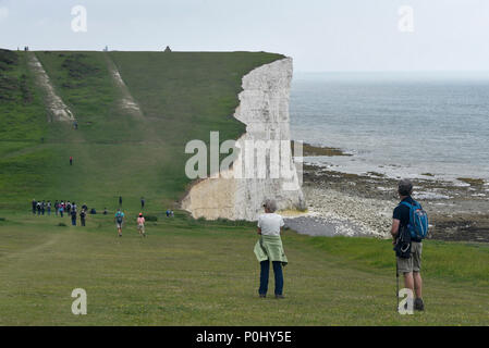 South Downs, UK.  9 June 2018.  Sightseers walk along the South Downs Way near Beachy Head on a warm afternoon.  In recent years, the area has been prone to erosion with areas of the chalk cliffs around Seven Sisters collapsing onto the beach below.  As a result walkers are warned not to go close to the cliff edge.  Credit: Stephen Chung / Alamy Live News Stock Photo