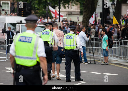 London, UK. 9th June, 2018. Police escort a supporter of Tommy Robinson, former leader of the far-right English Defence League, away from anti-fascists protesting against the March for Tommy Robinson outside Downing Street. Tommy Robinson was jailed for contempt of court after using social media to broadcast details of a trial subject to blanket reporting restrictions. Credit: Mark Kerrison/Alamy Live News Stock Photo