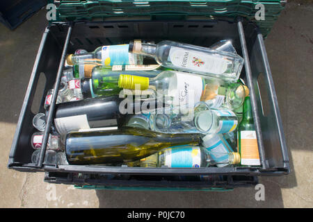 Collection of empty glass bottles waiting collection to a recycling centre - John Gollop Stock Photo