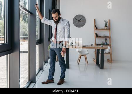 thoughtful young businessman standing in modern loft office Stock Photo