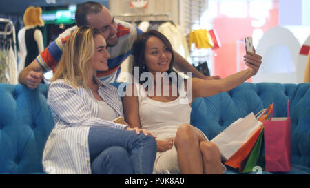 Group of hipsters in shopping mall taking selfie using smart phone Stock Photo