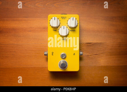 Yellow Guitar Effects Pedal On Wooden Surface Stock Photo
