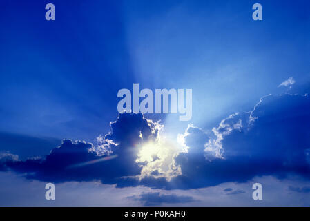 1995 HISTORICAL SUNBURST FLARES THROUGH PUFFY CLOUDS Stock Photo