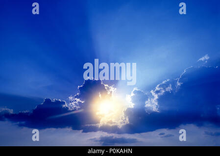 1995 HISTORICAL SUNBURST FLARES THROUGH PUFFY CLOUDS Stock Photo