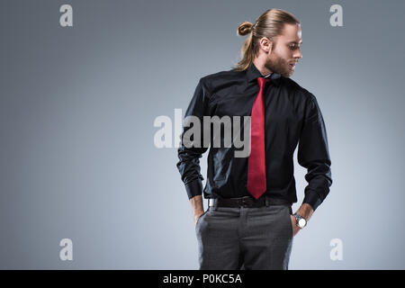 Young bearded man in black shirt with red tie looking away, isolated on  gray Stock Photo - Alamy