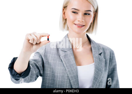 smiling woman holding one pill, isolated on white Stock Photo