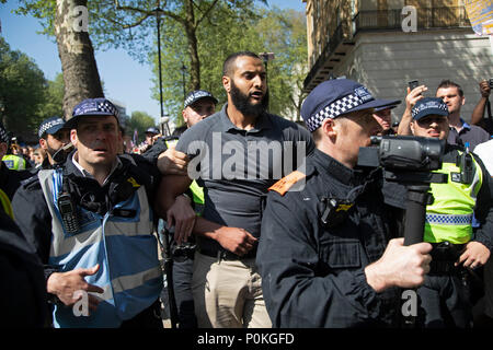 Mohammed Hijab who was originally supposed to speak at the rally is whisked away by police under protection after being set upon at the 'Democratic' Football Lads Alliance 'day of freedom' on May 6th in London, England, United Kingdom. The Football Lads Alliance FLA is a movement established in 2017. According to the Times ‘the movement was set up as a self-proclaimed 'anti-extremist' movement’, but has more and more become associated with far-right activists. (photo by Mike Kemp/In Pictures via Getty Images) Stock Photo