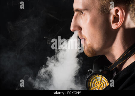 mask to filter cigarette smoke Man wearing protective filter mask exhaling smoke of electronic cigarette  Stock Photo