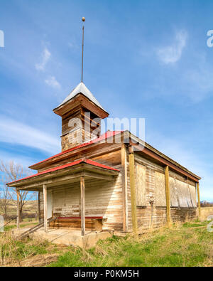 Windows are boarded up on this abandoned school house in the country Stock Photo