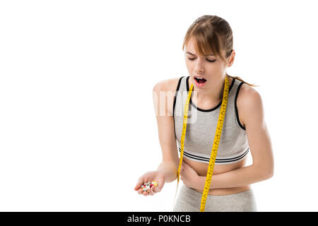 young woman with stomachache holding heap of pills isolated on white Stock Photo