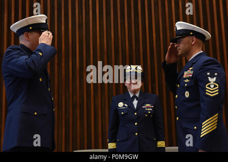 Command Master Chief Petty Officer James Bach passes the watch to Master Chief Petty Officer Jahmal Pereira during the Ninth Coast Guard District's change-of-watch ceremony in Cleveland, June 6, 2018. The ceremony was presided over by the Commander of the Coast Guard's Ninth District, Rear Adm. Joanna Nunan. Stock Photo