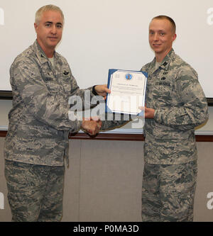 Col. Paul Quigley, Commander, 224th Air Defense Squadron, served as the promoting officer for Capt. Eric Schenck during the 224th Air Defense Group's recent promotion ceremony. Capt. Schenck was one of eight Airmen promoted at the ceremony. Stock Photo