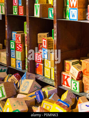 Shelf and Pile of colorful children’s alphabet wooden block toys Stock Photo