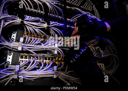 cropped shot of hackrers hands in gloves and various cables Stock Photo