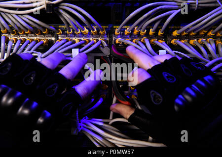 cropped shot of hackrers hands in gloves and various cables Stock Photo