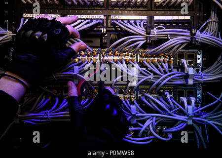 cropped shot of hackrers hands in gloves and various cables Stock Photo