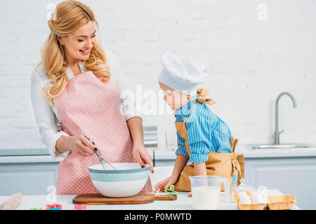 Mom and son in aprons play with flour while cooking at home in the kitchen  against the background of kitchen utensils. Selective focus. Portrait. Clos  Stock Photo - Alamy