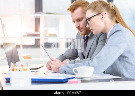 businesswoman and businessman working with documents and digital tablet at workplace in office Stock Photo