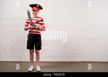 little smiling boy with toy knife and gun in pirate costume Stock Photo