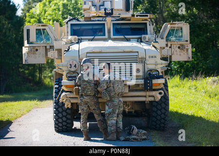 (From left) Sgt. Erin Dobbins, an explosive disposal team member with 49th Ordnance Company from Fort Campbell, Ky., and her team leader, Staff Sgt. James Ahn, collect information during the protective works lane at the 2018 Ordnance Crucible, Fort A.P. Hill, Va., June 6, 2018. EOD teams are assessed on operations and associated tasks require to provide EOD support to unified land operations to eliminate and/or reduce explosive threats. The Ordnance Crucible is designed to test Soldiers' teamwork and critical thinking sills as they apply technical solutions to real world problems improving rea Stock Photo
