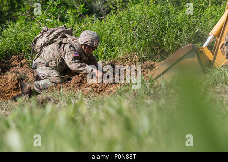 Staff Sgt. James Ahn, an explosive disposal team leader with 49th Ordnance Company from Fort Campbell, Ky., uncovers a simulated explosive device at the 2018 Ordnance Crucible, Fort A.P. Hill, Va., June 6, 2018. EOD teams are assessed on operations and associated tasks require to provide EOD support to unified land operations to eliminate and/or reduce explosive threats. The Ordnance Crucible is designed to test Soldiers' teamwork and critical thinking sills as they apply technical solutions to real world problems improving readiness of the force.  (U.S. Army photo by Spc. Nathanael Mercado) Stock Photo