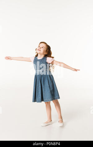 Little stylish kid in dress standing with wide arms isolated on white Stock Photo