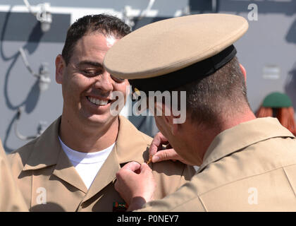 180608-N-PM193-054  SAN DIEGO (June 8, 2018) Senior Chief Information Systems Technician Jose Murillobarba receives his senior chief petty officer collar device during a pinning ceremony on the flight deck of amphibious assault ship USS Boxer (LHD 4). Boxer is pierside in its homeport preparing for Commander, Naval Surface Forces Pacific sea trials. (U.S. Navy photo by Mass Communication Specialist 3rd Class Alexander C. Kubitza/Released) Stock Photo