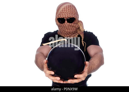 A lighted bomb in the outstretched hands of a young man hidden under a arafatka and black glasses on a white background. Stock Photo