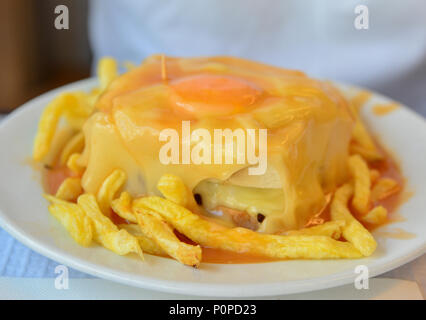 A portuguese sandwich Francesinha served with french fries original dish in Porto, Portugal Stock Photo