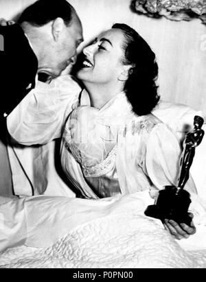 Description: The 18th Academy Awards / 1946.   Michael Curtiz with Joan Crawford, winner of the best actress award for 'Mildred Pierce'..  Year: 1946.  Stars: JOAN CRAWFORD. Stock Photo