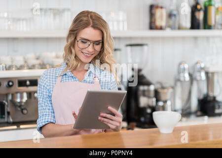 young waitress using digital tablet during work in coffee shop Stock Photo