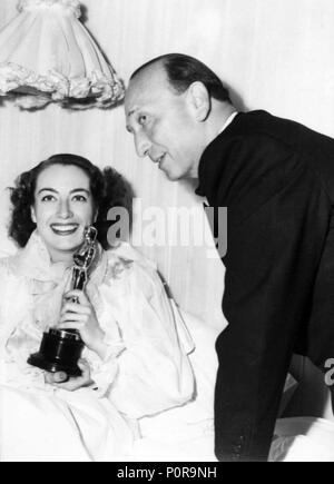 Description: The 18th Academy Awards / 1946.   Michael Curtiz with Joan Crawford, winner of the best actress award for 'Mildred Pierce'..  Year: 1946.  Stars: MICHAEL CURTIZ; JOAN CRAWFORD. Stock Photo