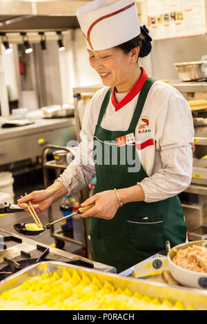 Nanjing, Jiangsu, China.  Cook in Restaurant Kitchen Making Egg Dumplings with Pork. Stock Photo