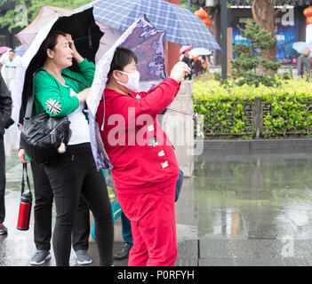 Nanjing, Jiangsu, China.  Woman with Breathing Mask Taking a Photo with her Cell Phone. Stock Photo