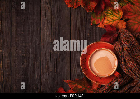 Autumn background with hot chocolate, knitted scarf, multi-colored leaves. Top view with copy space. Stock Photo