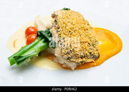 Fine food: Grilled Barramundi with mash potato, broccoli, cherry tomatoes and carrot puree Stock Photo