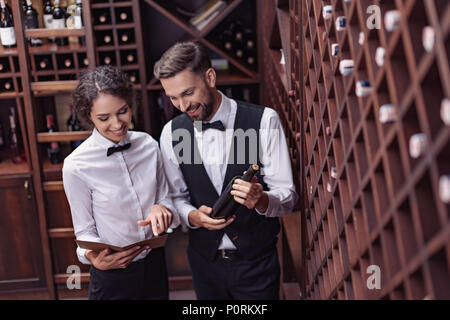 two young professional sommeliers choosing wine in wine cellar Stock Photo