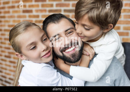 portrait of little siblings hugging happy father Stock Photo