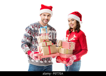 happy young couple holding stacks of christmas gifts and looking at camera isolated on white Stock Photo