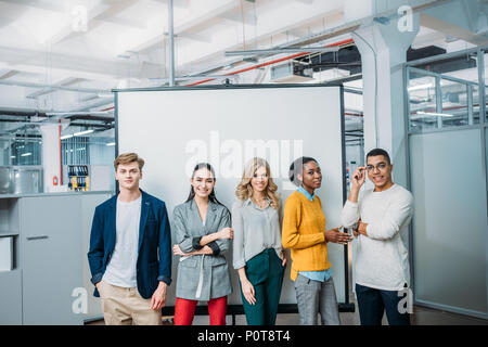 group of young business partners standing in front of whiteboard Stock Photo