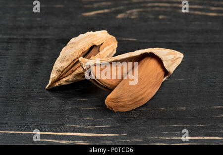 Wild uzbek inshell almonds on dark table Stock Photo