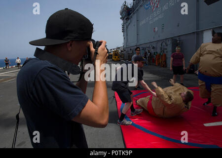 5TH FLEET AREA OF OPERATIONS (May 5, 2017) Seaman Kai Vinson takes photos of a sumo wrestling game during a steel beach picnic aboard the amphibious assault ship USS Bataan (LHD 5). The ship is currently deployed with the Bataan Amphibious Ready Group in support of maritime security operations designed to reassure allies and partners and preserve the freedom of navigation and the free flow of commerce in the region. Stock Photo